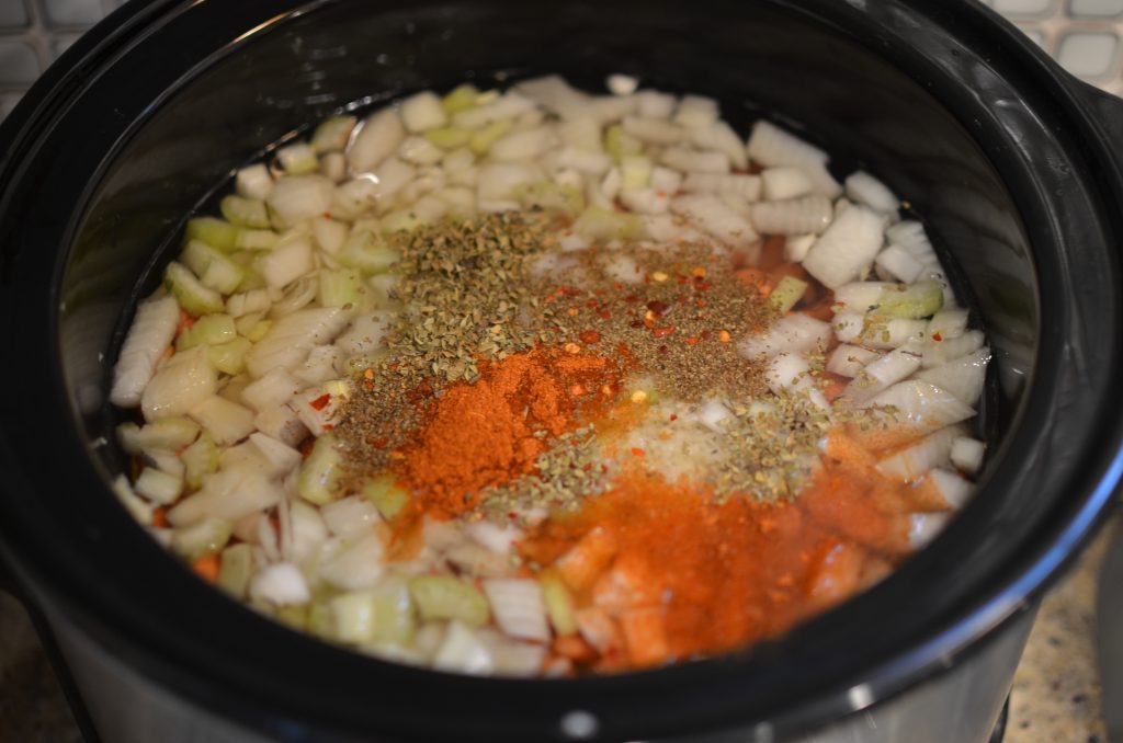 Dry kidney beans in a crock pot with veggies, spices, and water.