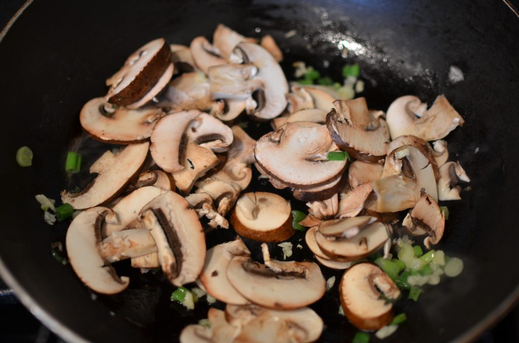Crimini mushrooms added to the wok.