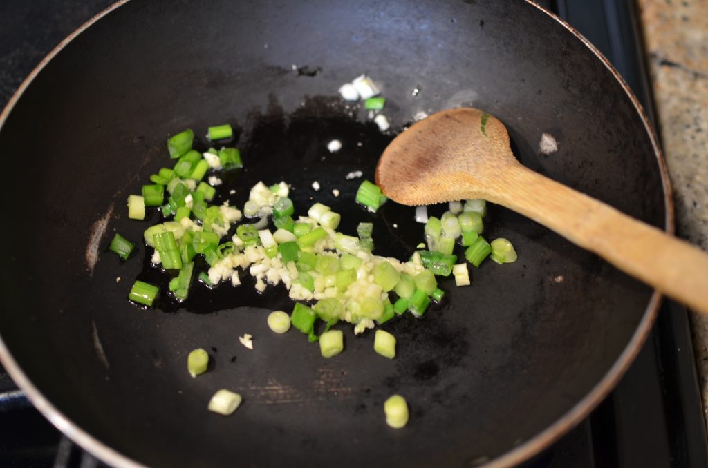 Sauteing garlic and onions in a wok.