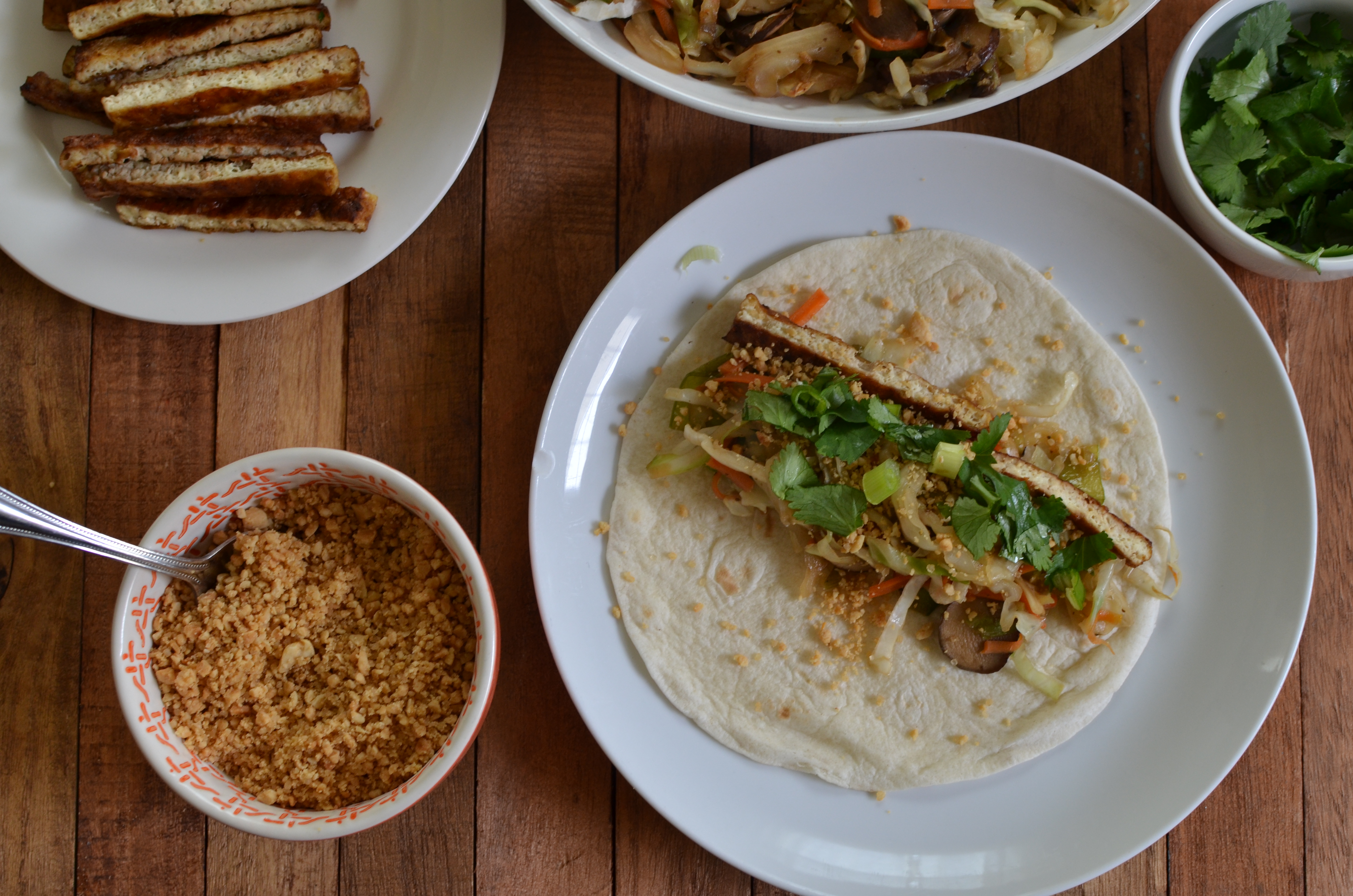 Filling the tortilla with the vegetables, tofu, and peanut powder.