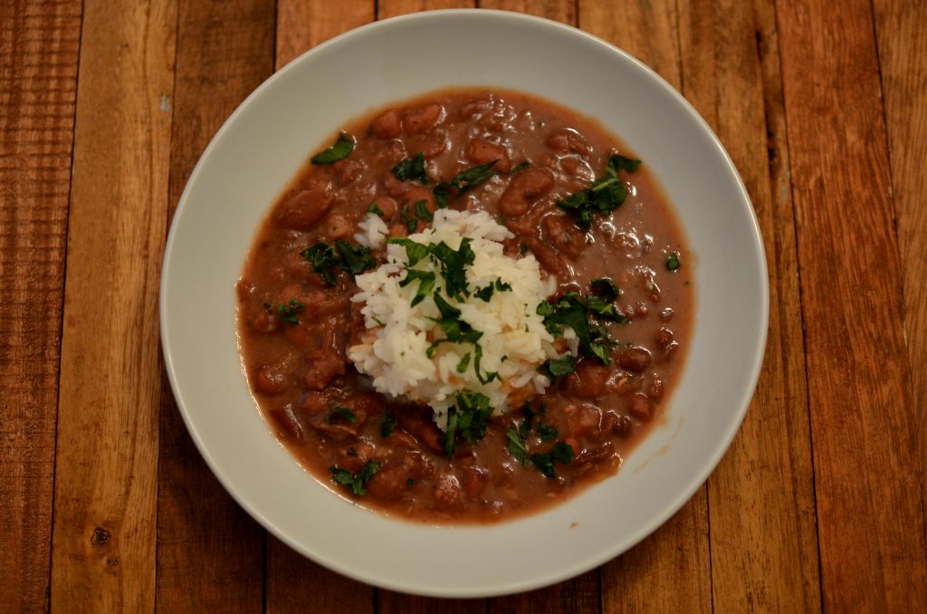Red beans served with long grain white rice and garnished with parsely.